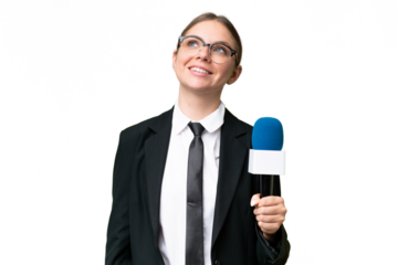 Young TV presenter caucasian woman  over isolated background looking up while smiling