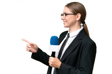 Young TV presenter caucasian woman  over isolated background pointing to the side to present a product