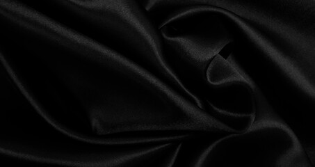 Smooth elegant black silk or satin luxury cloth texture as abstract background. Luxurious background design