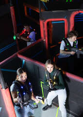 Four people playing lasertag in labyrinth arena
