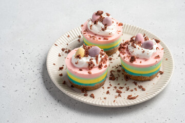 Easter mini cheesecakes with candy eggs and whipped cream.