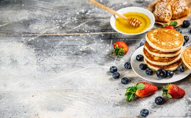 Pancakes in a plate with berries and honey. 