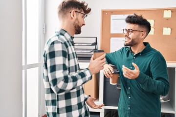 Obraz premium Young couple business workers drinking coffee standing at office