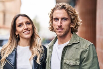 Fototapeta premium Man and woman couple smiling confident standing together at street