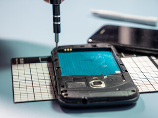 A technician repairs a smartphone in a laboratory with copy space. concept of computer hardware,...