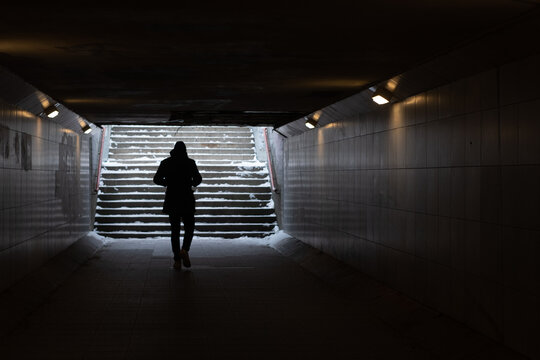 Man Walking In Dark Underground Tunnel In Winter. Stranger Anonymous Person. Unknown Person In Subway. Horror And Thriller Concept.