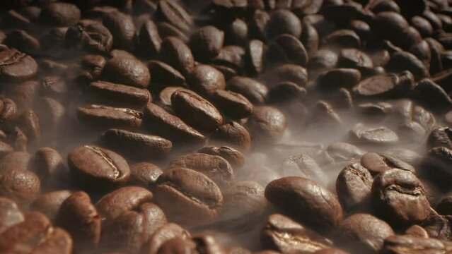 Aromatic coffee beans are roasted in frying pan,smoke comes from coffee beans. Soft diffuse smoke coming from roasted coffee beans.Macro shot coffee bean roasting moke coming from bean roasting