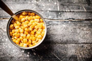 An open can of canned corn with a spoon. 