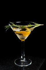 Transparent alcohol cocktail Smoky Martini with lemon zest and rosemary on black background.
