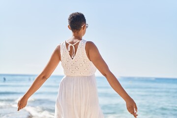 Fototapeta na wymiar African american woman standing on back view at seaside