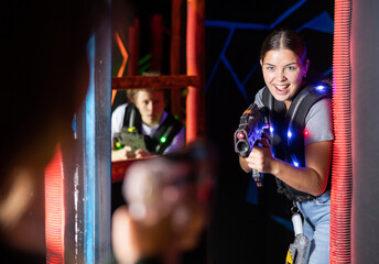 Girl running and dodging while playing lasertag