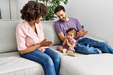 Couple and daughter smiling confident sitting on sofa at home