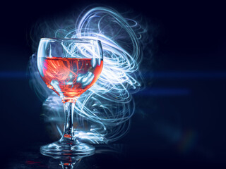 Glass or red wine, dark background with blue light painting effect. Alcohol product for a special occasion.