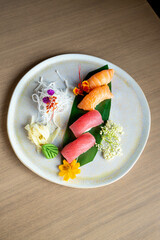 four nigiri sushi with salmon and tuna served on fresh green banana leaf on black background with japanese sign © leo