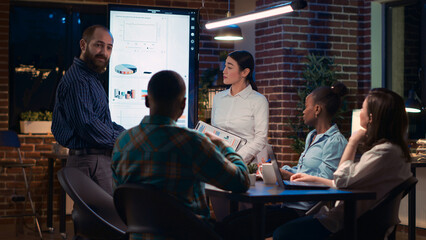 Business coaches giving presentation, company team training in meeting. Coworkers standing near digital board screen, marketing strategy planning, financial analytics report. tripod shot.