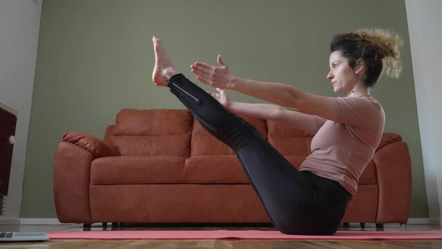 One woman doing daily practice yoga sequence at home on the floor