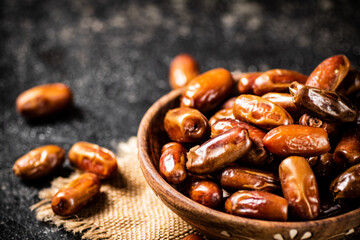 Full wooden plate with dates on the table. 