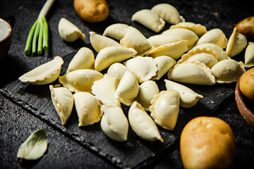 Potato dumplings on a stone board with green onions. 
