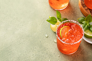 Strawberry basil margarita with lime wedges on the table