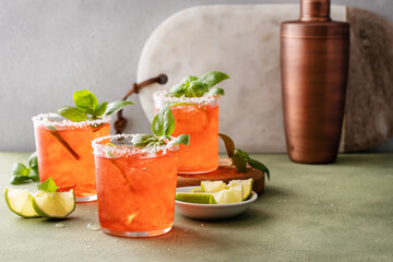 Strawberry basil margarita with lime wedges on the table