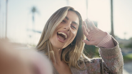 Obraz premium Young blonde woman smiling confident having video call at street