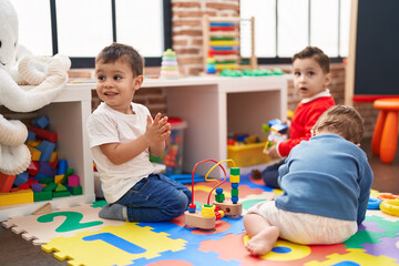 Obraz premium Group of kids playing with toys sitting on floor at kindergarten
