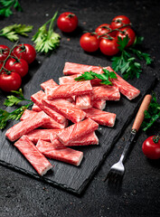 Crab meat on a stone board with fresh tomatoes and herbs. 