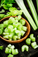 Sliced fresh celery. On a dark wooden background.