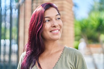 Young beautiful hispanic woman smiling confident looking to the side at street