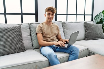Young caucasian man smiling confident using laptop at home