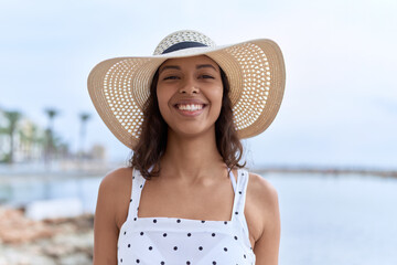 Young african american woman smiling confident wearing summer hat at seaside
