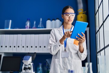 Young african american woman scientist using touchpad at laboratory