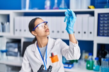 Young african american woman scientist measuring liquid at laboratory