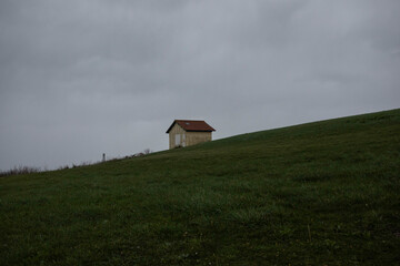 Small shed on top of hill during rain storm