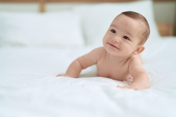 Adorable toddler smiling confident lying on bed at bedroom