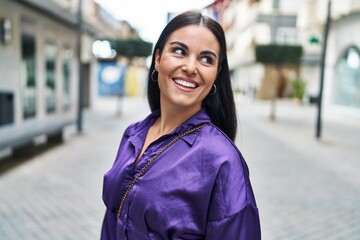 Young beautiful hispanic woman smiling confident looking to the side at street