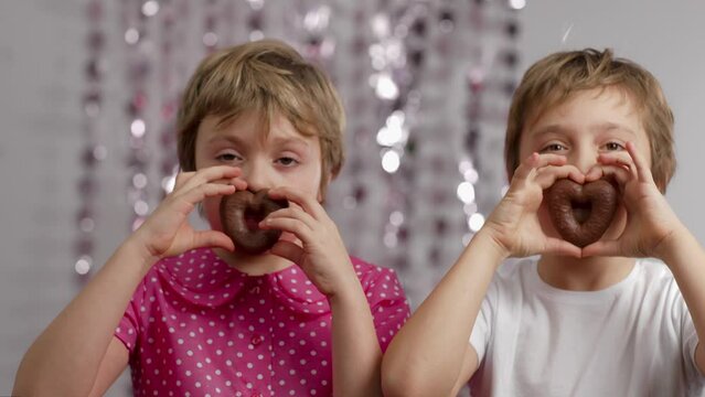 Gingerbread in the shape of hearts in the hands of girl and boy. 