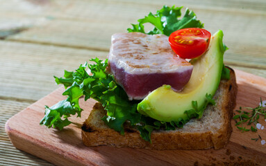 Fototapeta na wymiar Toasted bread with tuna steak, salad, avocado and cherry tomato