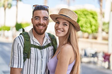 Man and woman tourist couple smiling confident hugging each other at street