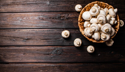 Obraz na płótnie Canvas Basket with fresh mushrooms. On a wooden background. 