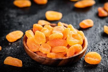 Dried apricots in a wooden plate on the table. 