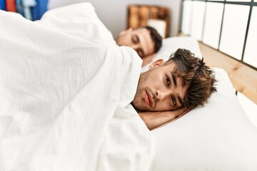 Two hispanic men couple sleeping at bedroom