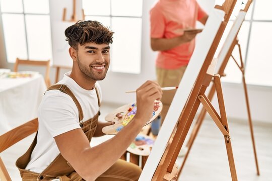 Two hispanic men couple smiling confident drawing at art studio