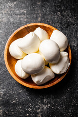 Mozzarella cheese in a wooden plate on the table. 