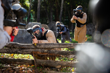 Fototapeta premium Portrait of adult people with guns during paintball game on outdoors arena