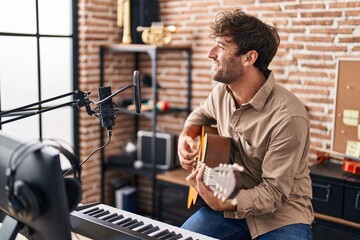 Young man musician singing song playing classical guitar at music studio