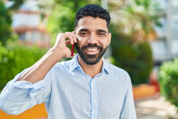 Young arab man smiling confident talking on the smartphone at park