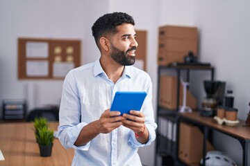 Young arab man business worker smiling confident using touchpad at office