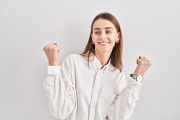 Young caucasian woman standing over isolated background celebrating surprised and amazed for success with arms raised and eyes closed. winner concept.