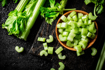 Pieces of celery in a wooden plate on the table.
